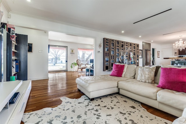 living room with hardwood / wood-style floors, an inviting chandelier, and crown molding