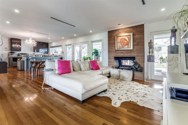 living room with hardwood / wood-style flooring, a fireplace, and an inviting chandelier