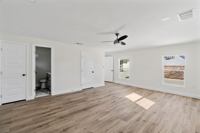 interior space featuring ceiling fan, light wood-type flooring, and ensuite bathroom