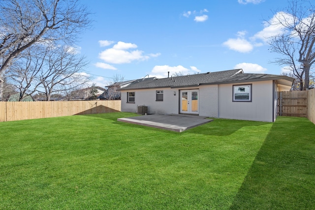 rear view of property featuring central AC unit, a patio area, french doors, and a lawn