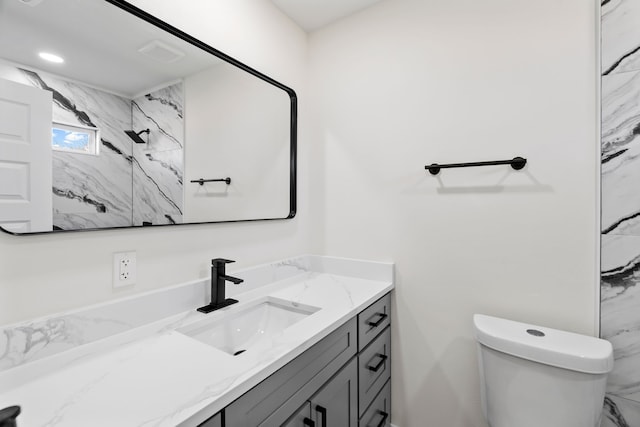 bathroom featuring toilet, walk in shower, and vanity