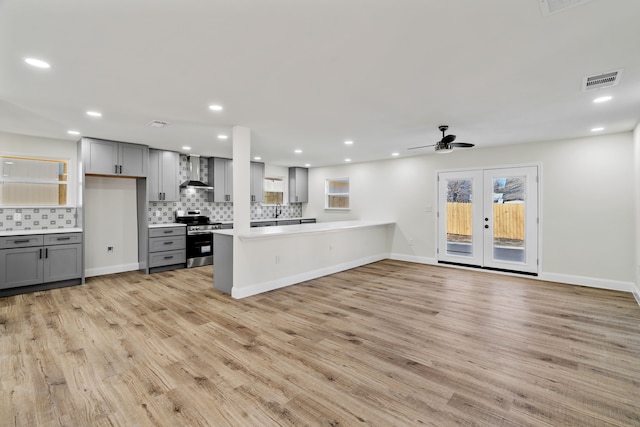 kitchen featuring light hardwood / wood-style floors, electric range, gray cabinetry, and wall chimney exhaust hood