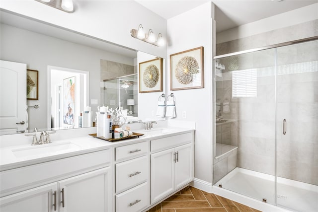 bathroom with a shower with door and vanity