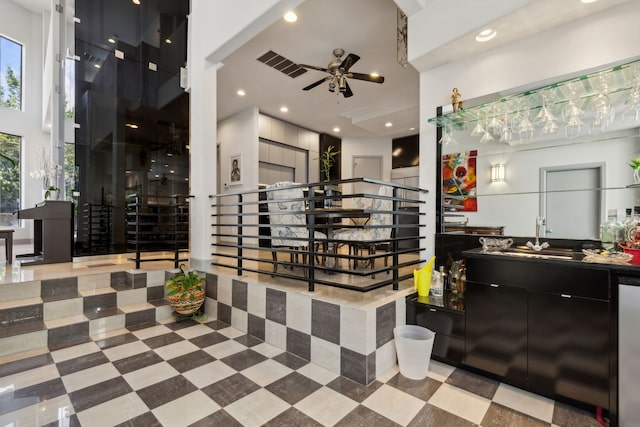 interior space with ceiling fan and bar