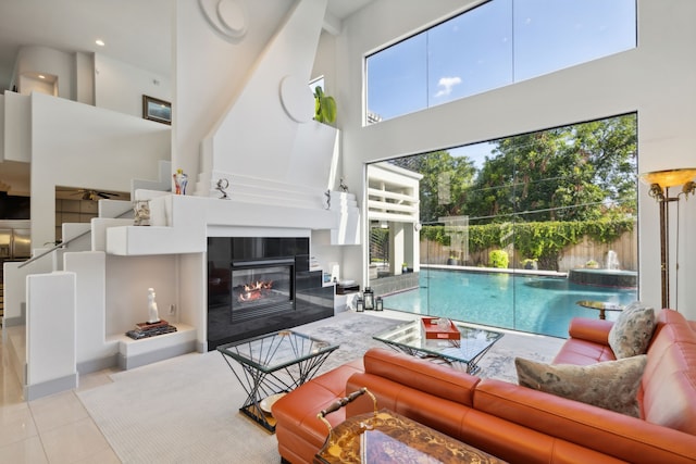 tiled living room with a fireplace and a high ceiling