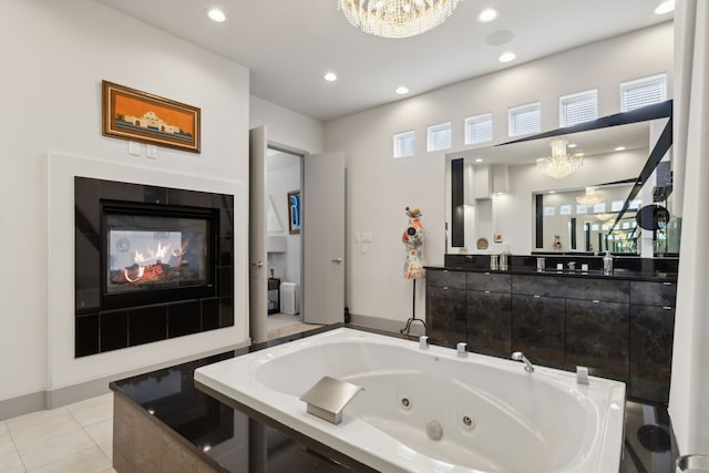 bathroom featuring a chandelier, a relaxing tiled tub, tile patterned floors, and a tiled fireplace