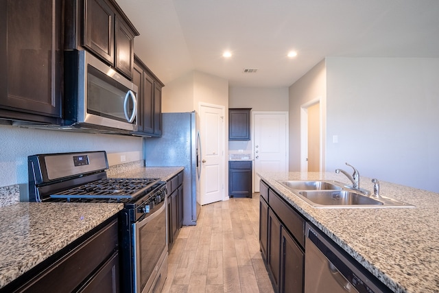 kitchen featuring light stone countertops, sink, stainless steel appliances, and light hardwood / wood-style flooring