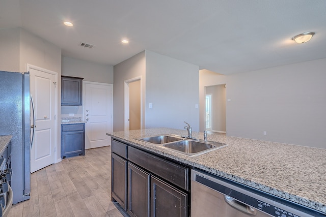 kitchen featuring sink, stainless steel appliances, light stone counters, light hardwood / wood-style flooring, and dark brown cabinets