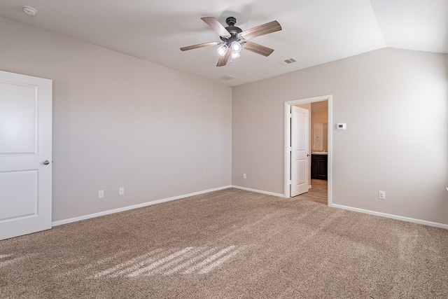 empty room featuring carpet flooring, vaulted ceiling, and ceiling fan