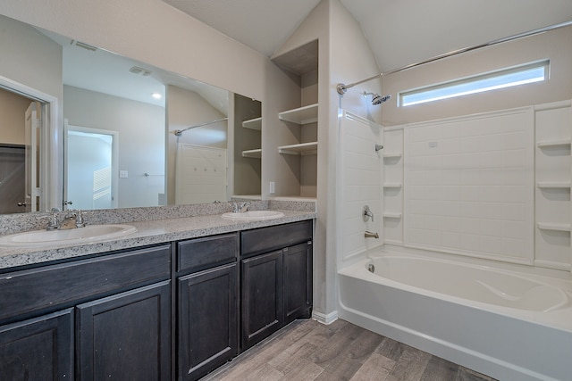 bathroom featuring shower / bathing tub combination, hardwood / wood-style floors, vanity, and lofted ceiling