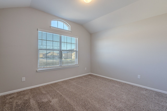 carpeted empty room featuring lofted ceiling