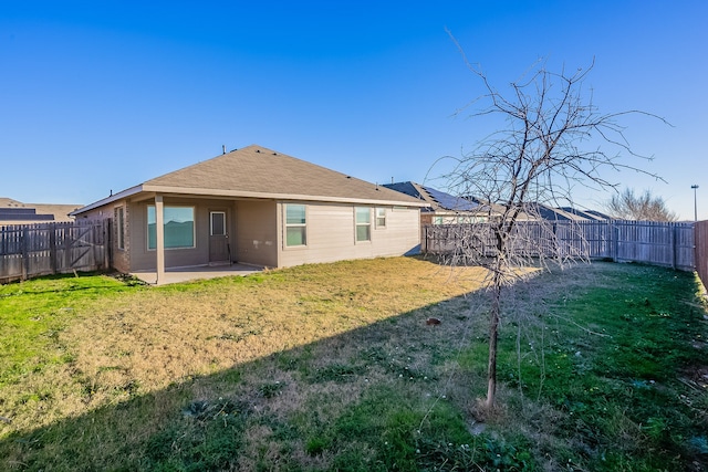 rear view of house featuring a patio and a lawn