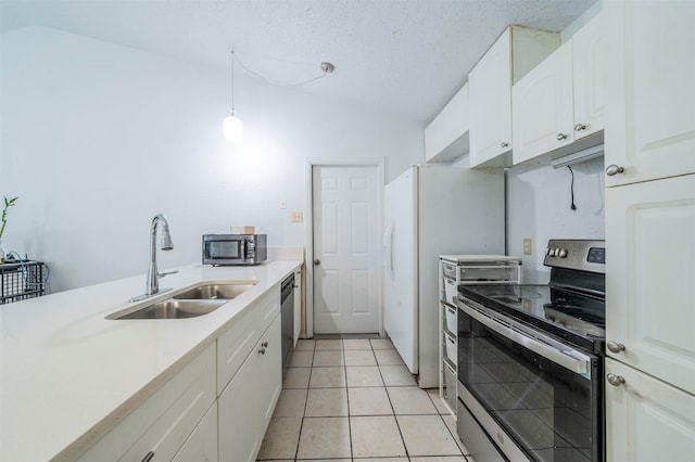 kitchen featuring hanging light fixtures, sink, white cabinets, light tile patterned floors, and stainless steel appliances