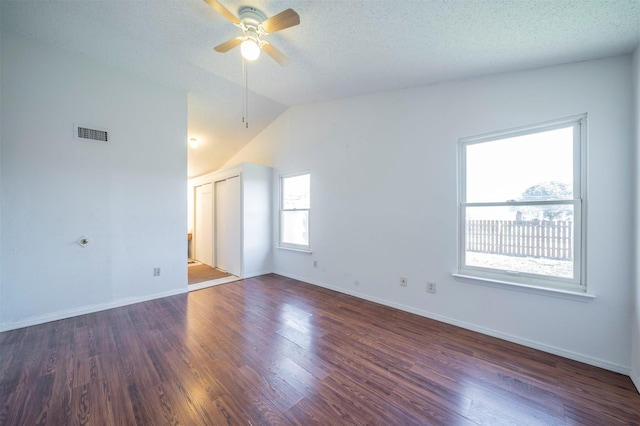 spare room with ceiling fan, a textured ceiling, dark hardwood / wood-style floors, and lofted ceiling