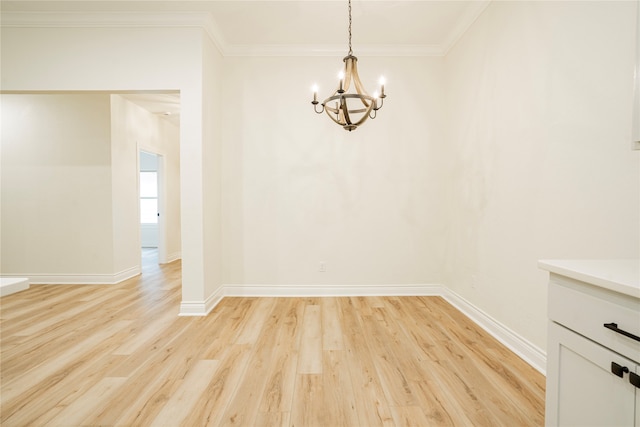 unfurnished dining area with ornamental molding, light hardwood / wood-style floors, and a chandelier