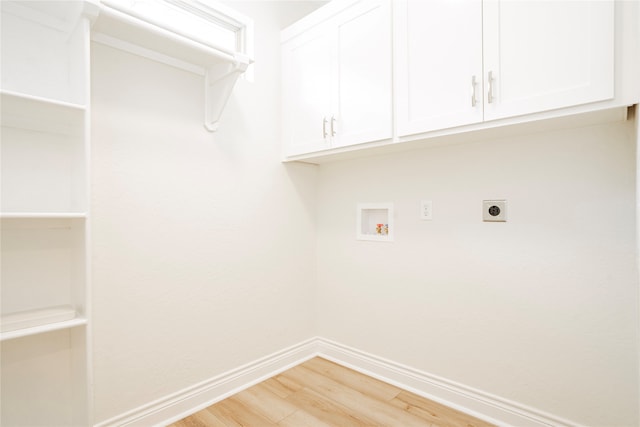 laundry room with electric dryer hookup, hookup for a washing machine, cabinets, and light hardwood / wood-style flooring