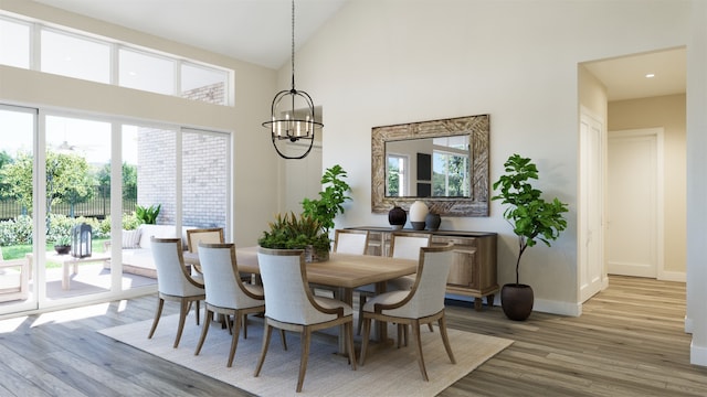 dining area with a notable chandelier, light hardwood / wood-style floors, and high vaulted ceiling