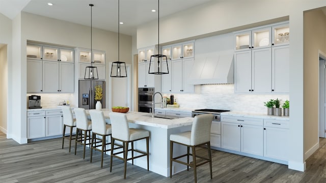 kitchen with white cabinets, premium range hood, and appliances with stainless steel finishes