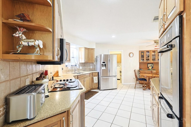 kitchen with stainless steel appliances, sink, light tile patterned floors, separate washer and dryer, and decorative backsplash