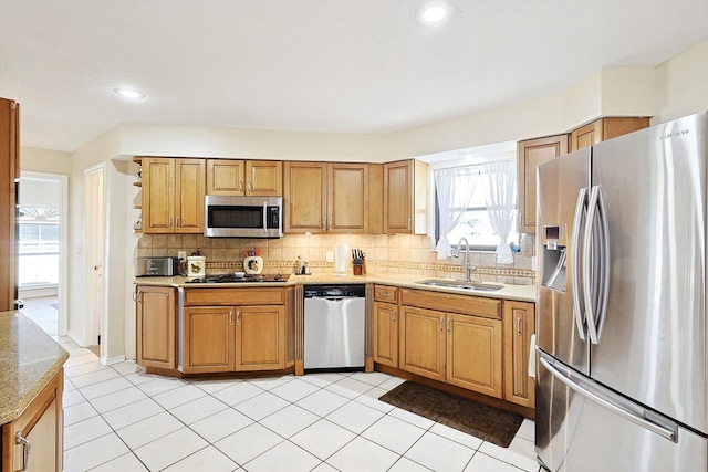 kitchen with stainless steel appliances, light tile patterned flooring, sink, and tasteful backsplash