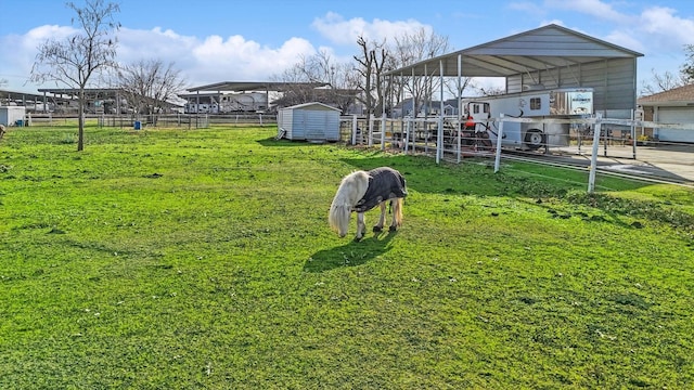 view of yard with a rural view and a storage shed