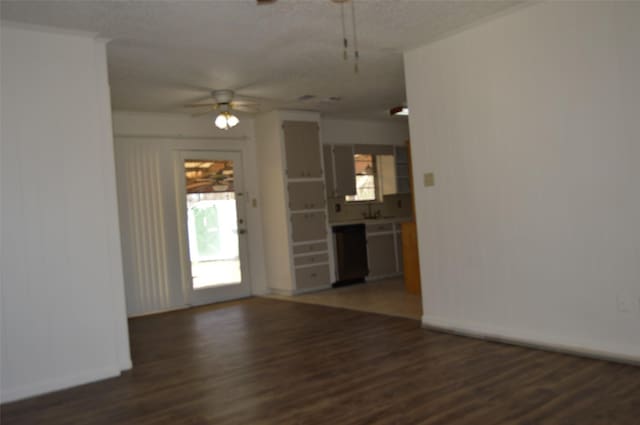 unfurnished living room featuring ceiling fan and dark hardwood / wood-style flooring