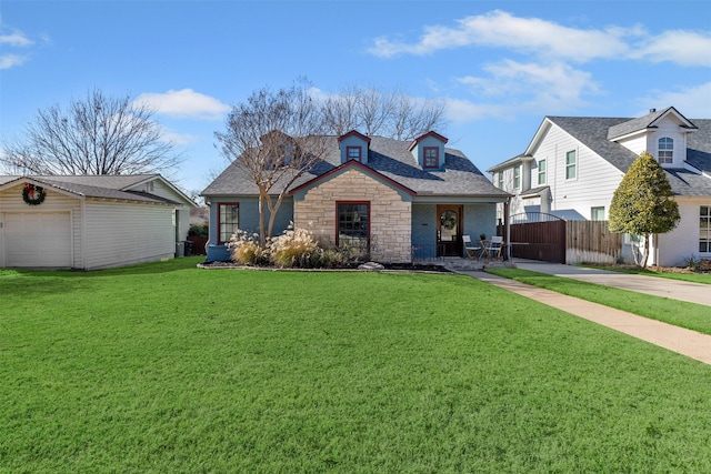 view of front of property with covered porch, a front lawn, a garage, and an outdoor structure