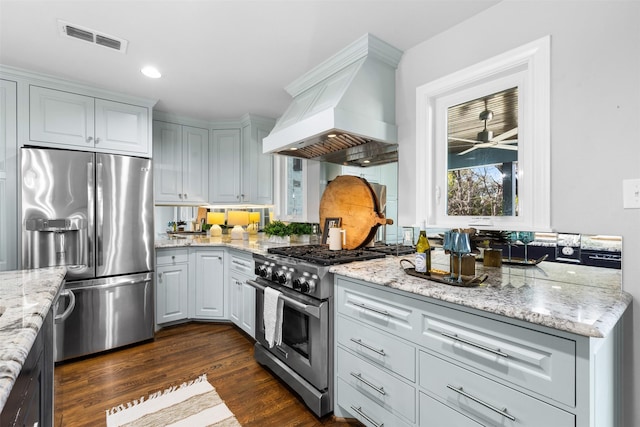 2548 Walsh Ct, Fort Worth, TX 76109 - kitchen featuring appliances with stainless steel finishes, custom exhaust hood, dark wood-style floors, light stone countertops, and a ceiling fan