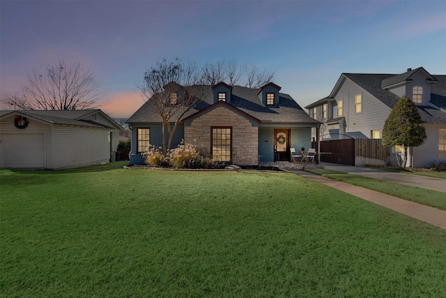 view of front of house with a lawn, a garage, and an outbuilding