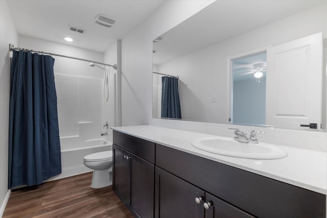 full bathroom with hardwood / wood-style floors, toilet, vanity, and shower / tub combo with curtain