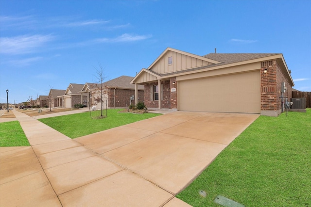 view of front of home featuring a garage, a front lawn, and central air condition unit