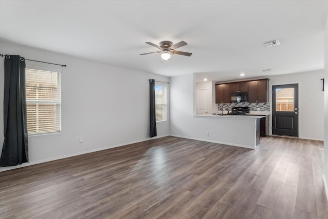 unfurnished living room with ceiling fan and dark wood-type flooring