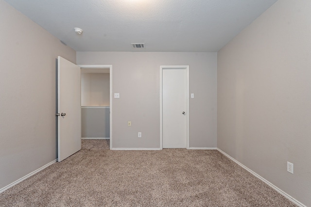 unfurnished bedroom featuring carpet floors and a textured ceiling