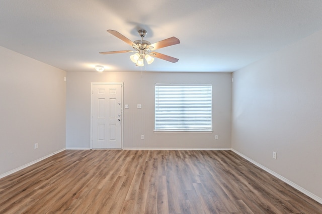 empty room featuring ceiling fan and dark wood-type flooring