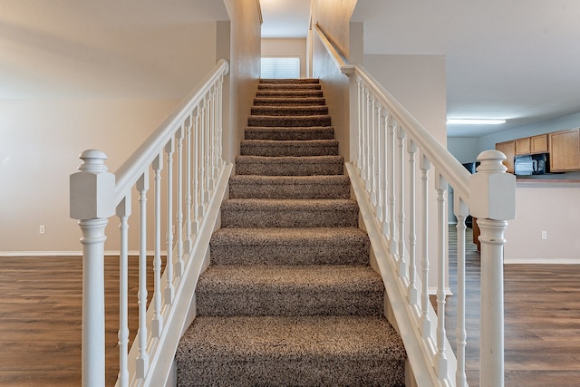 stairway with hardwood / wood-style floors