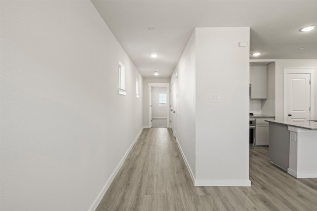 hallway with light hardwood / wood-style flooring