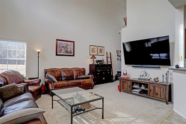 living room with a high ceiling and light carpet