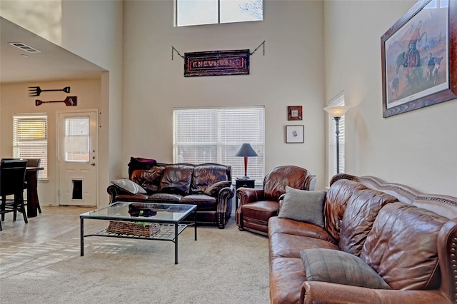 living room featuring a high ceiling and light carpet