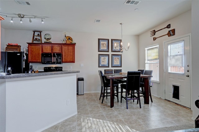 kitchen featuring black appliances, a notable chandelier, decorative light fixtures, and light tile patterned floors