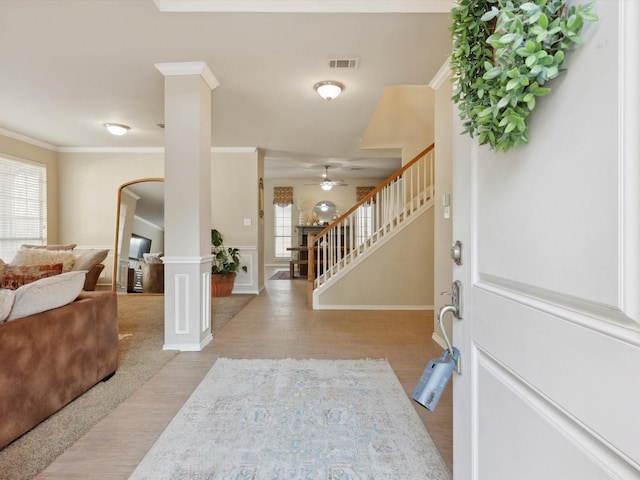 foyer with crown molding, ceiling fan, and light wood-type flooring