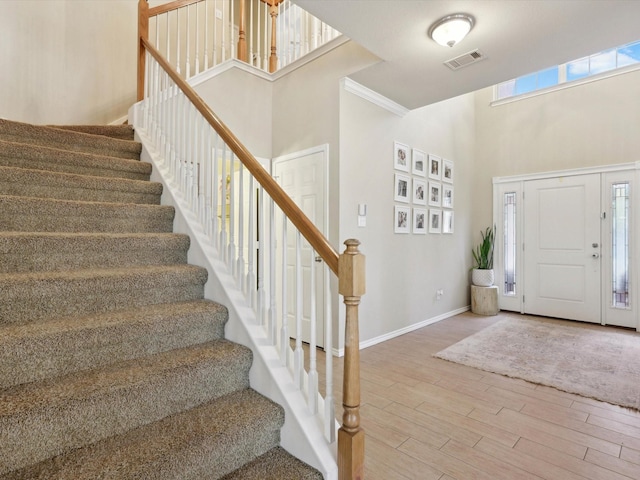 foyer featuring hardwood / wood-style floors, a healthy amount of sunlight, and ornamental molding