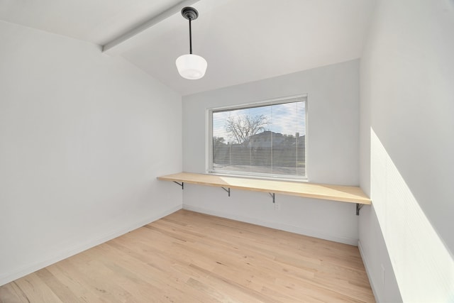 unfurnished office featuring lofted ceiling with beams and light hardwood / wood-style flooring