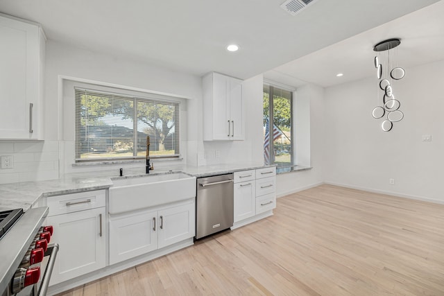 kitchen with white cabinetry, sink, a healthy amount of sunlight, tasteful backsplash, and appliances with stainless steel finishes