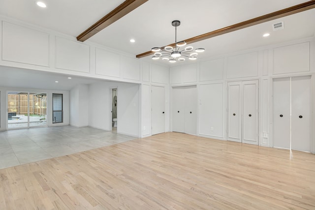 interior space with beamed ceiling, light hardwood / wood-style floors, and an inviting chandelier