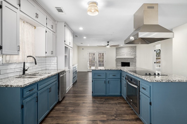 kitchen with blue cabinetry, island exhaust hood, appliances with stainless steel finishes, and white cabinets