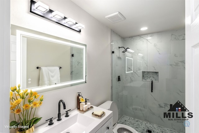 bathroom featuring vanity, toilet, and a shower with door