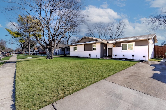 ranch-style home with a front yard, fence, and stucco siding