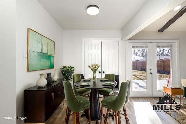 dining room with light wood-type flooring and french doors