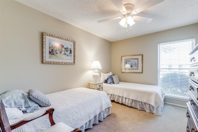 carpeted bedroom featuring ceiling fan and a textured ceiling