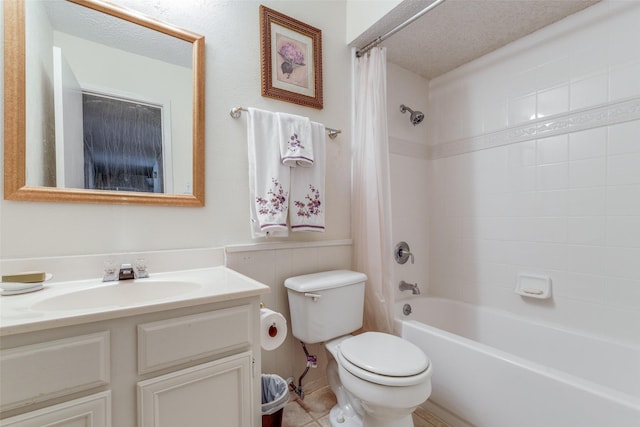 full bathroom featuring tile patterned flooring, a textured ceiling, toilet, shower / bath combo with shower curtain, and vanity